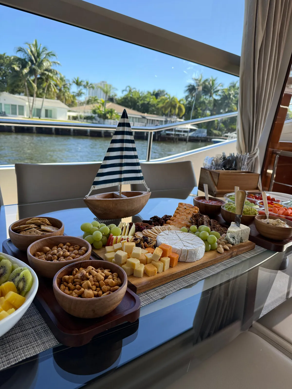 The charcuterie board with brie, blue cheese, grapes and crackers on the aft table at the dock